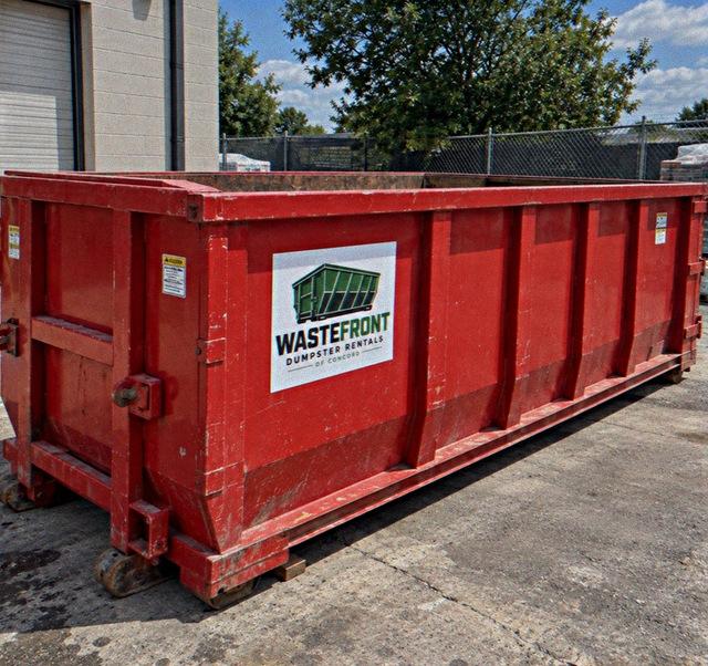 Red container positioned against the wall of a commercial building