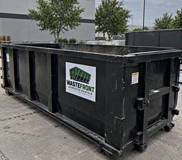 Black container standing in a paved commercial lot